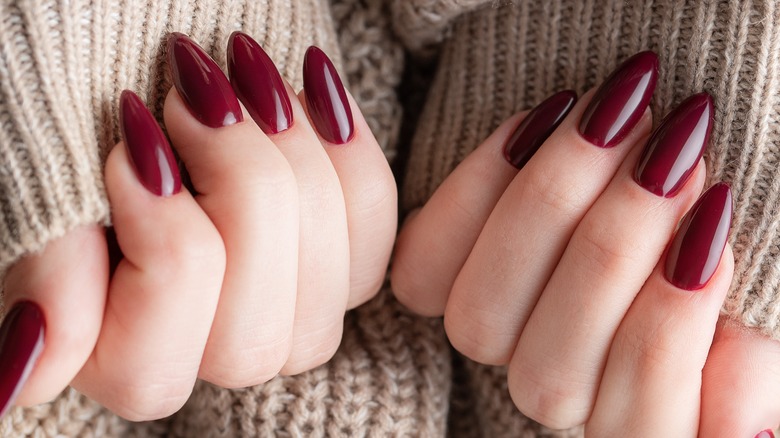 Dark red nails in a woolly sweater
