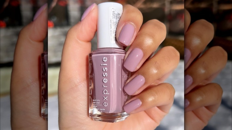 hand holding mauve nail polish bottle