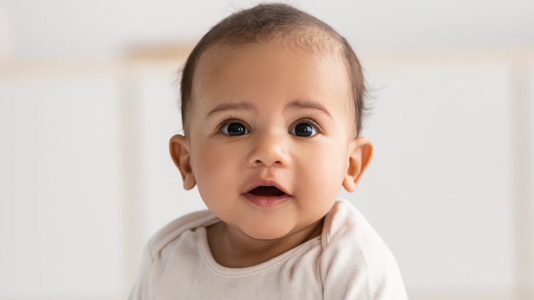 Baby sitting on a bed