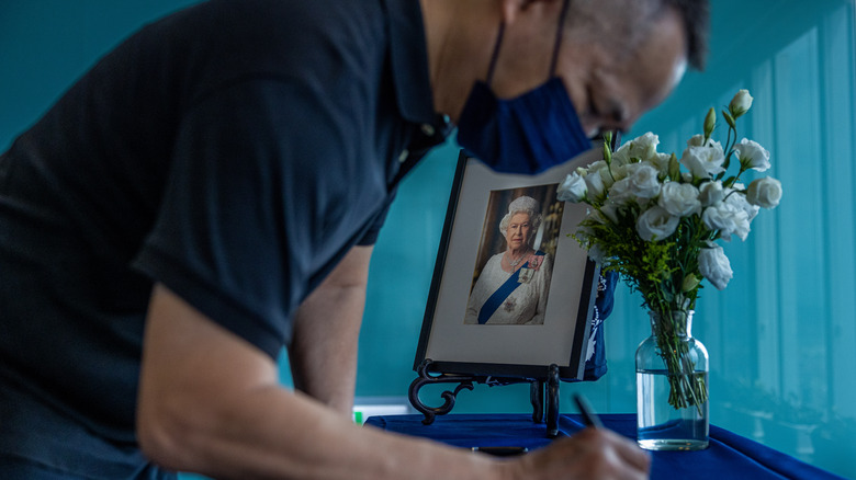 Man in Taiwan signing a book of condolences for Queen Elizabeth II