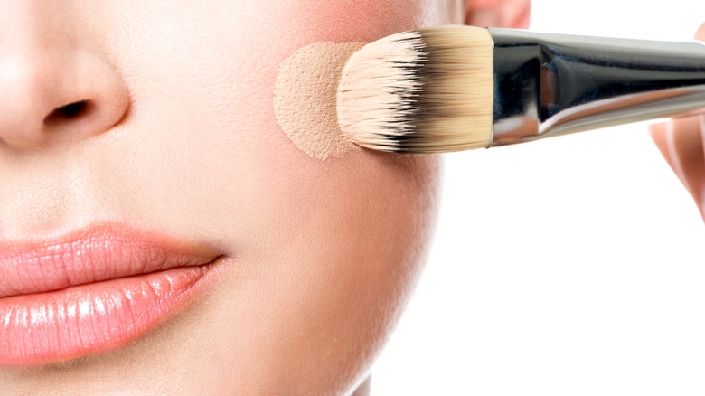 Woman applying liquid foundation with a brush