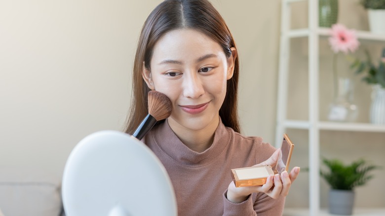 Woman applying powder foundation