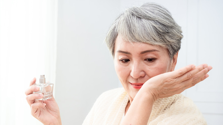 Woman putting on pefume 