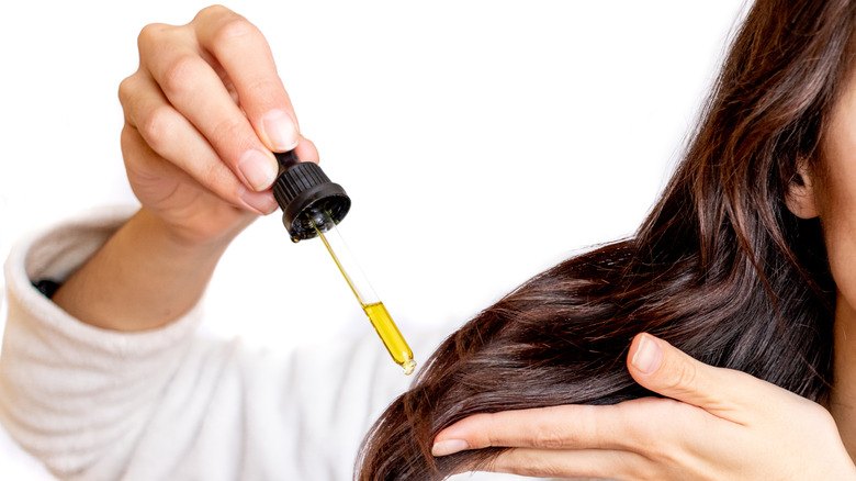 Woman applying hair serum