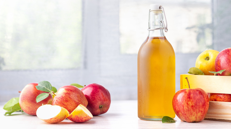 Glass bottle next to apples