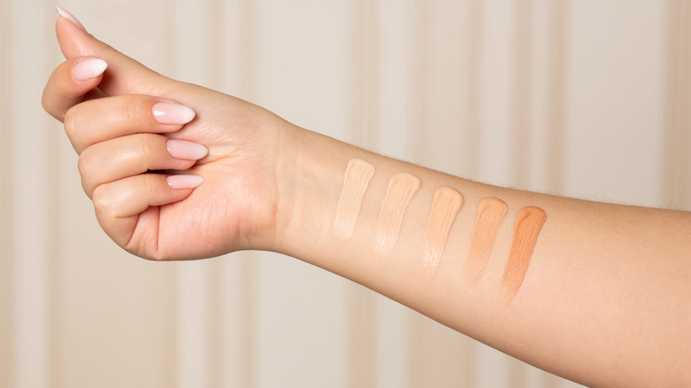 woman swatching makeup on arm