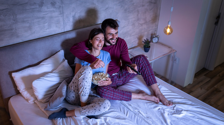 Couple in bed watching TV