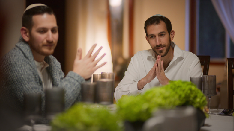 Men wearing kippahs sitting at table on "Jewish Matchmaking"