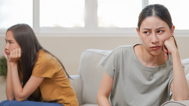 Two women angry on sofa 