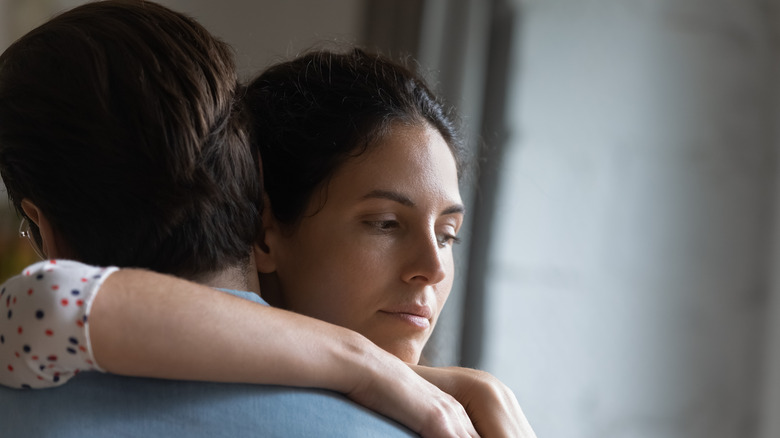 Woman thinking while embracing