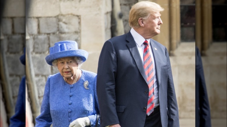 Donald Trump walking in front of Queen Elizabeth II 