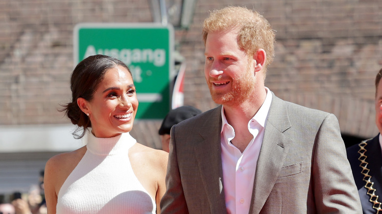 Meghan Markle smiles at Prince Harry while walking