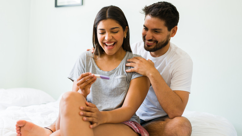 happy couple looking at pregnancy test