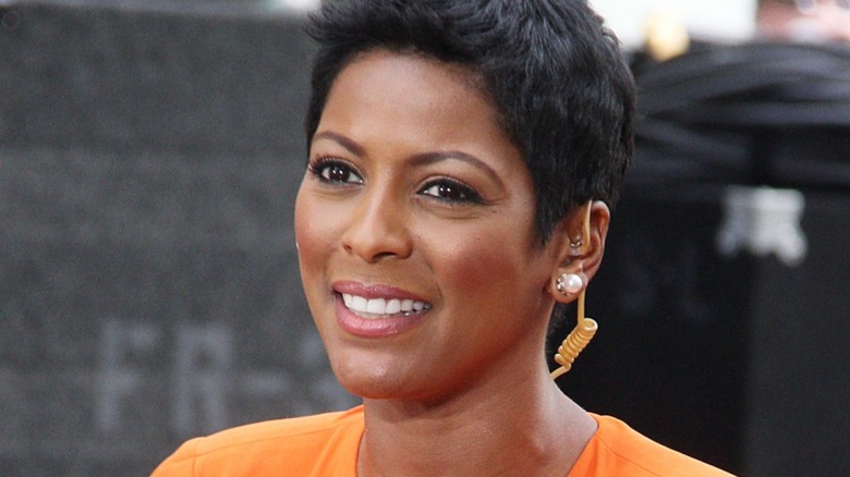 Tamron Hall smiling in orange dress