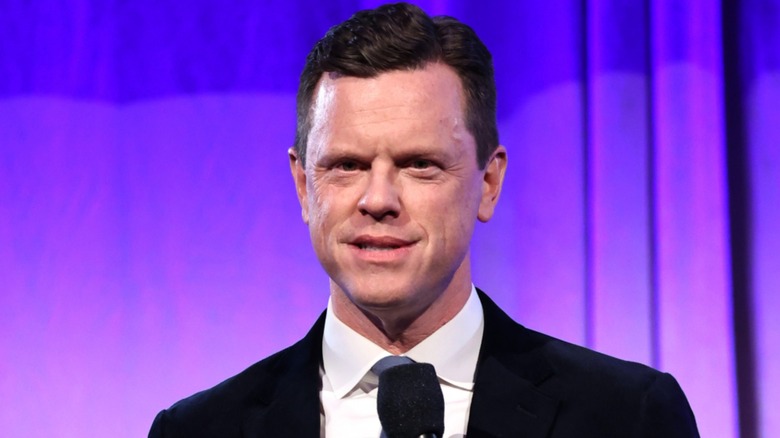 Willie Geist in front of purple curtain