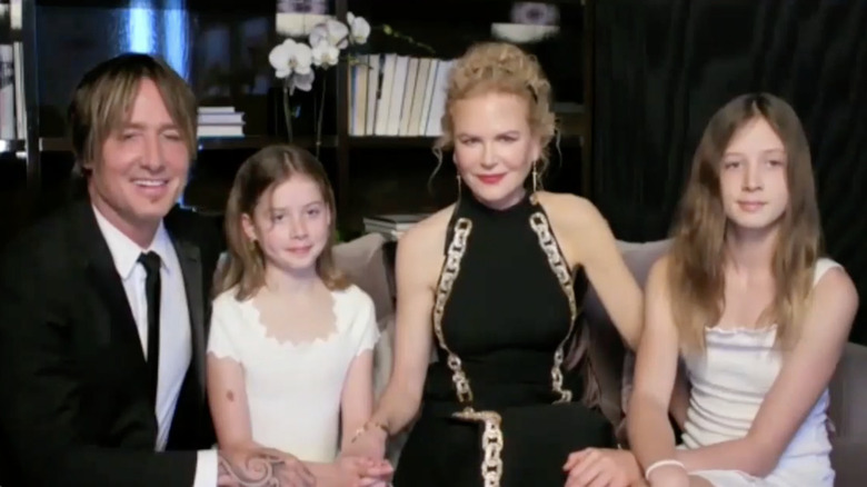 Keith Urban and Nicole and their daughters sitting on a couch at 2021 Golden Globes