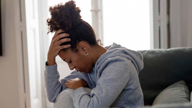 a woman holding her head in her hand. 