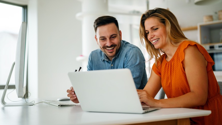 Man, woman working together, smiling