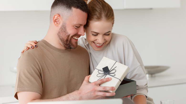 Man impressing woman with gift