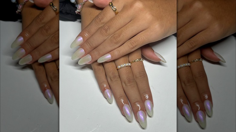 Hands featuring white nails with reflective finish