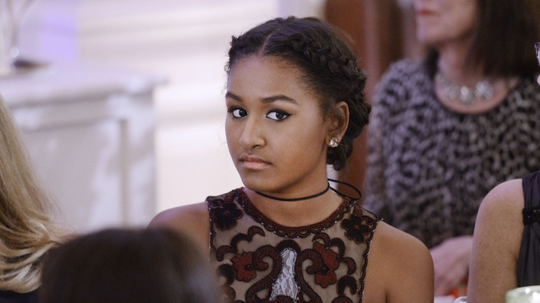 Sasha Obama looking serious in a lace dress