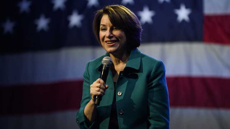 Klobuchar in front of American flag