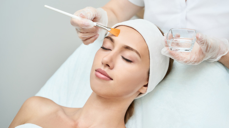 woman brushing liquid over face