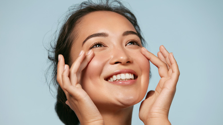 Woman holding face smiling