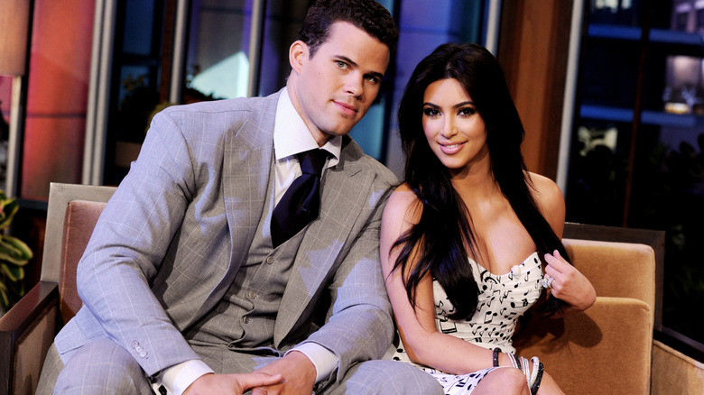 Kris Humphries and Kim Kardashian sitting on a couch together