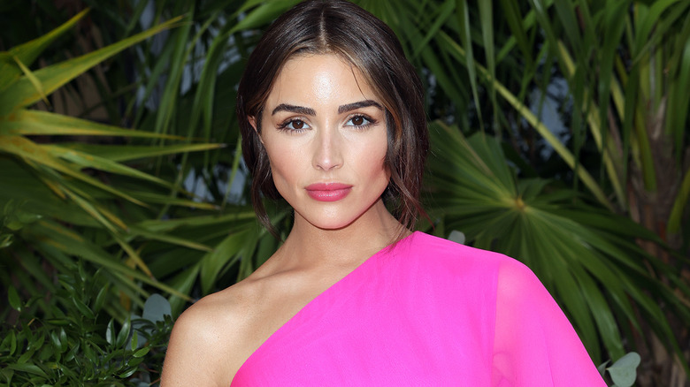 Olivia Culpo wears a pink one-shouldered gown.