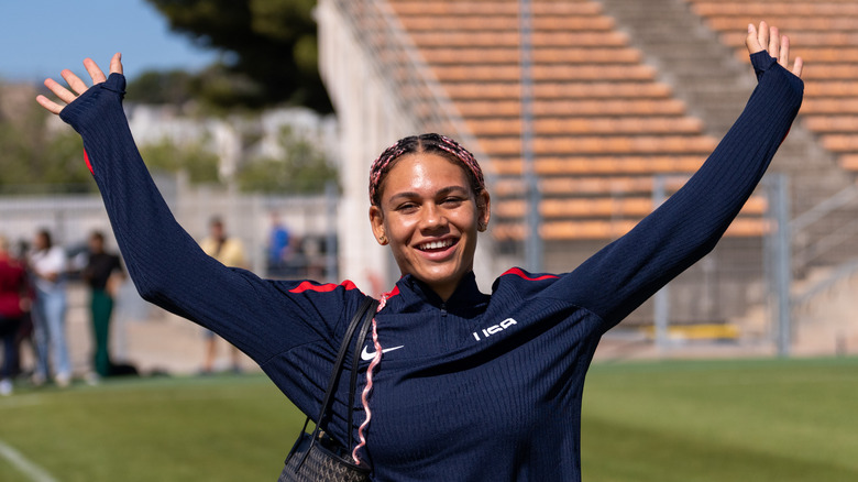 Trinity Rodman raising her hands up