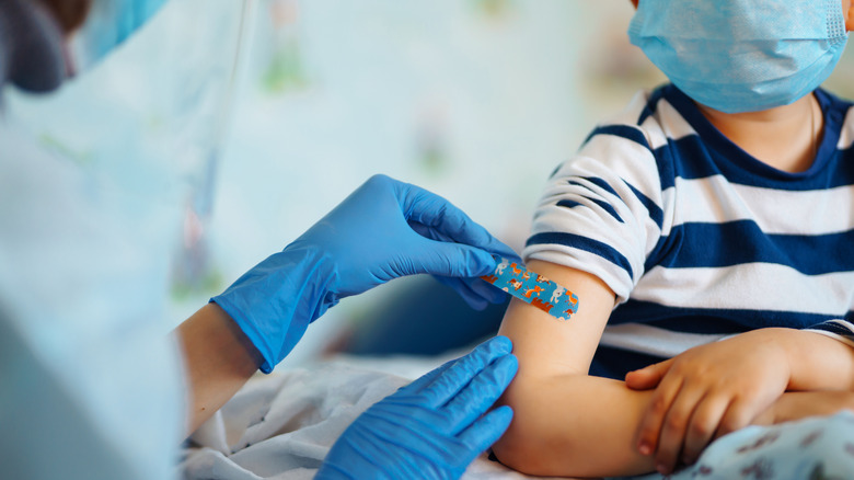 Doctor putting bandaid on child's arm