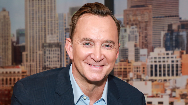 Clinton Kelly wearing a suit, smiling