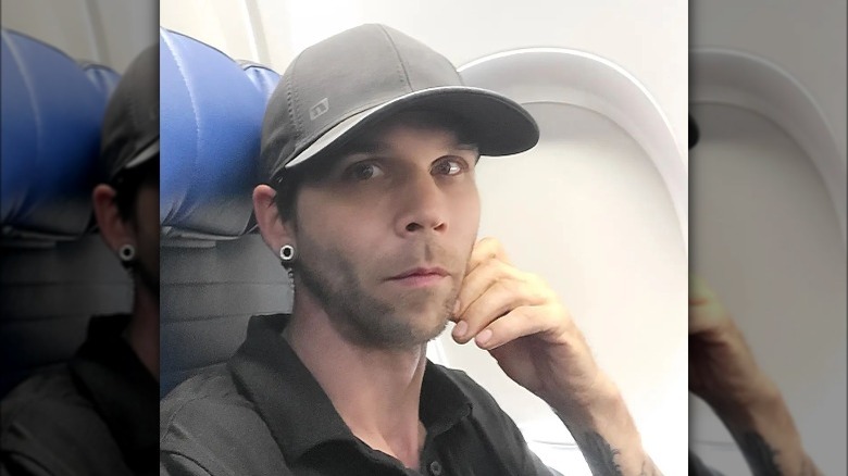 Jeremiah Raber wearing a hat, taking selfie on plane