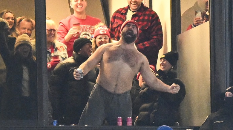 Jason Kelce screaming shirtless in a stadium suite