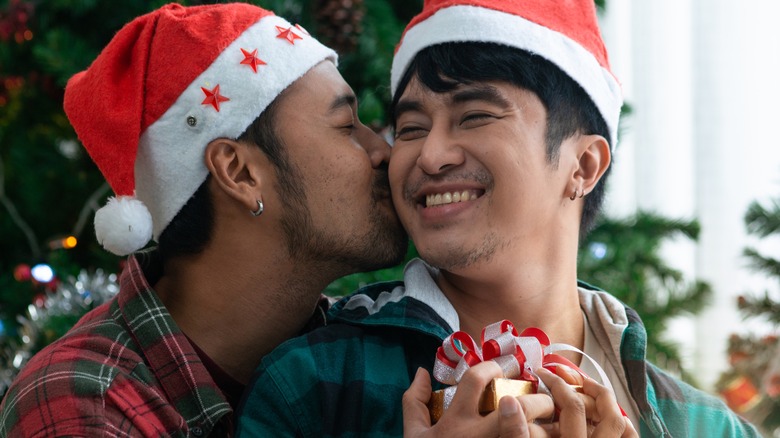 Couple embracing wearing santa hats