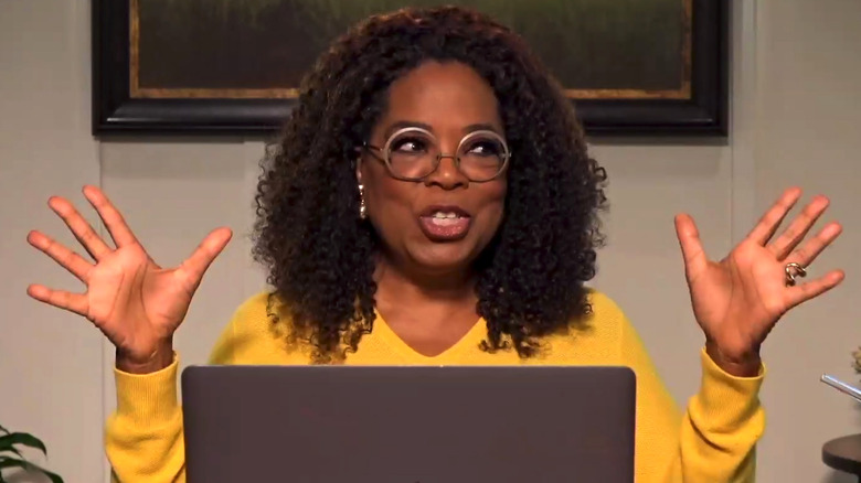 Oprah on computer with hands raised