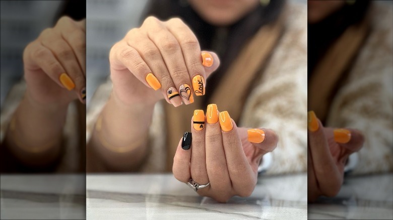 Orange nails with black doodles