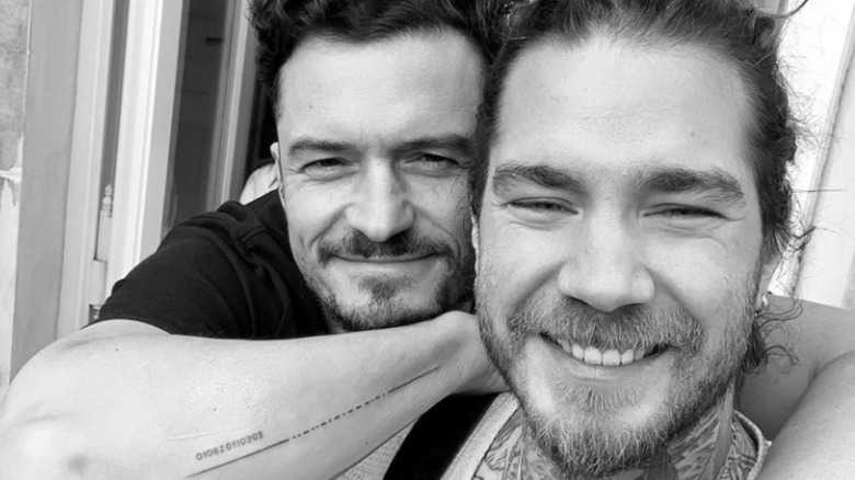 Orlando Bloom hugging tattoo artist