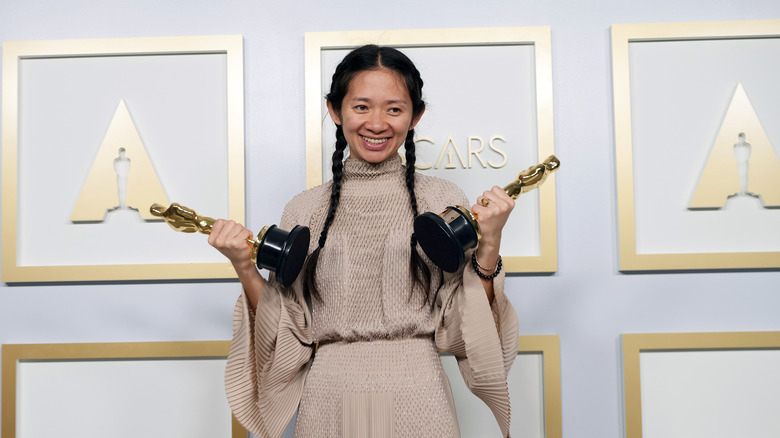 Chloe Zhao posing with awards
