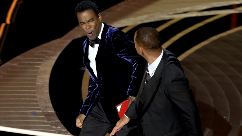 Chris Rock reacts to being slapped by Will Smith onstage at the Oscars