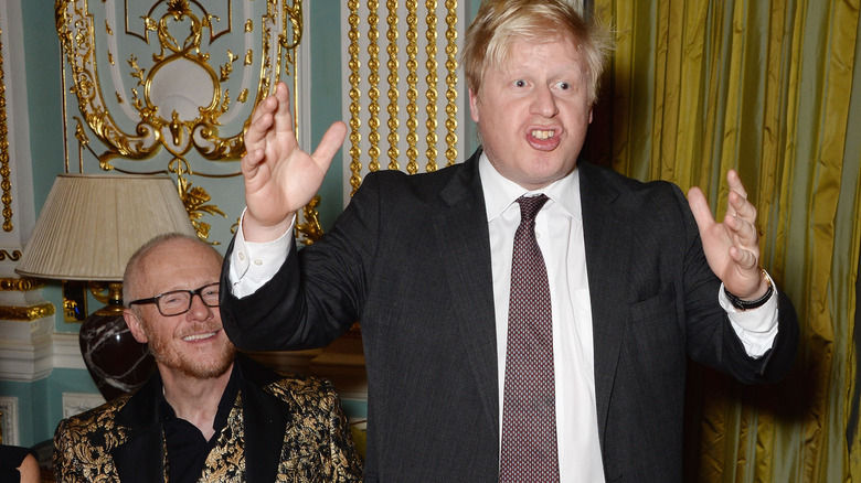 Boris Johnson at a dinner, speaking and gesturing