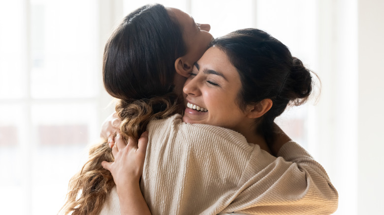 Two women huggung 