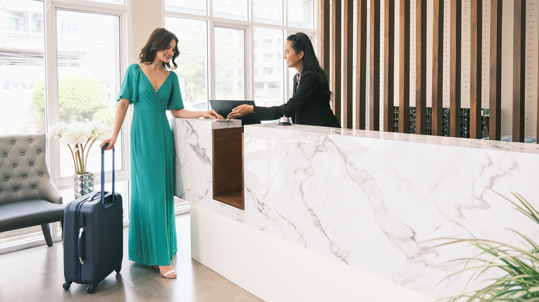 A woman checking into a hotel 