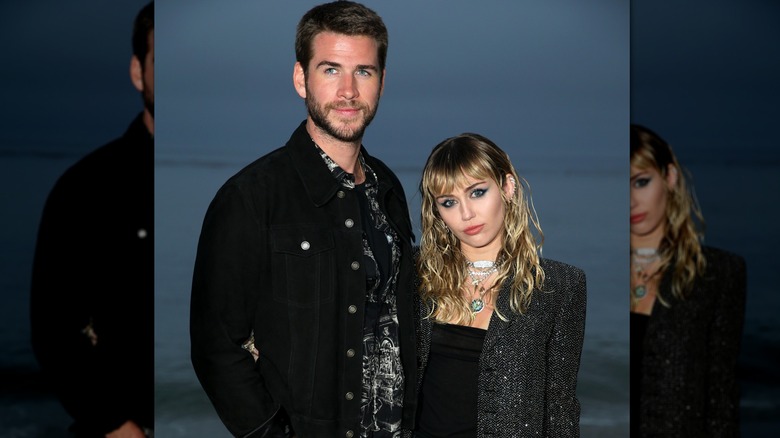 Miley Cyrus and Liam Hemsworth standing together