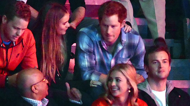 Cressida Bonas with her arm around Prince Harry in audience