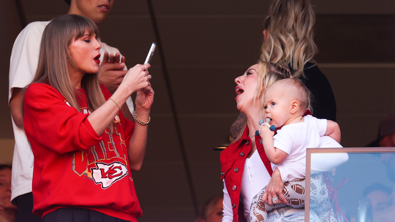 Taylor Swift taking a photo of Brittany Mahomes