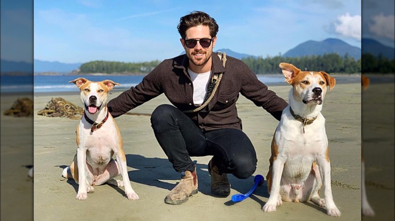 Chris McNally posing on the beach with his dogs