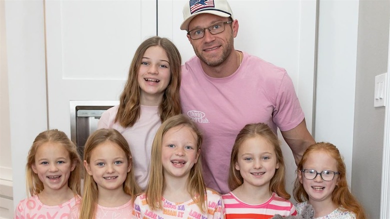 Adam Busby posing with six daughters