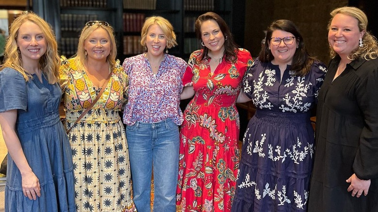 Erin Napier smiling with a group of women wearing dresses